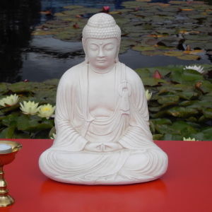 weiße Buddha-Statue vor Seerosen
